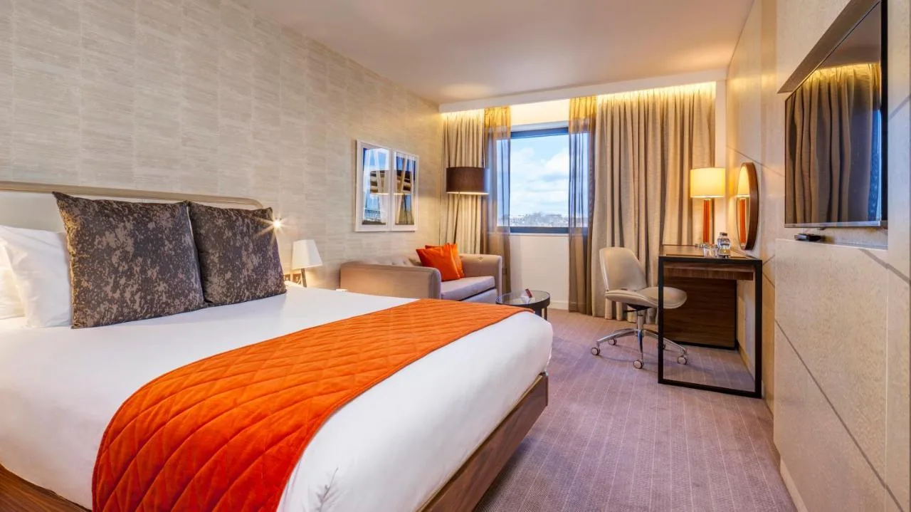 a hotel room with a large bed and a desk at Crowne Plaza London Kings Cross by IHG in London