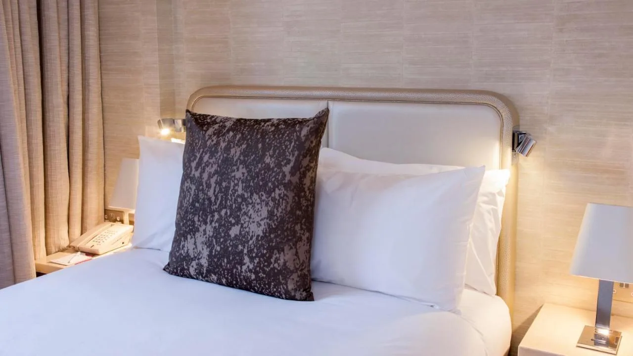 a bed with a black pillow sitting on top of it at Crowne Plaza London Kings Cross by IHG in London