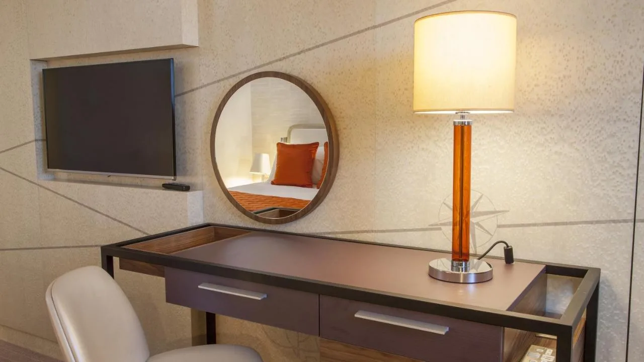 a room with a desk with a lamp and a mirror at Crowne Plaza London Kings Cross by IHG in London