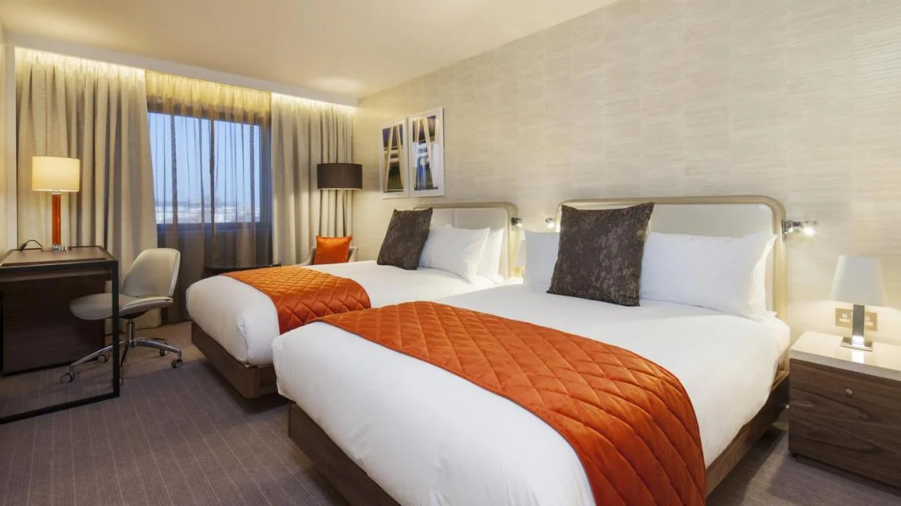 a hotel room with two beds and a television at Crowne Plaza London Kings Cross by IHG in London